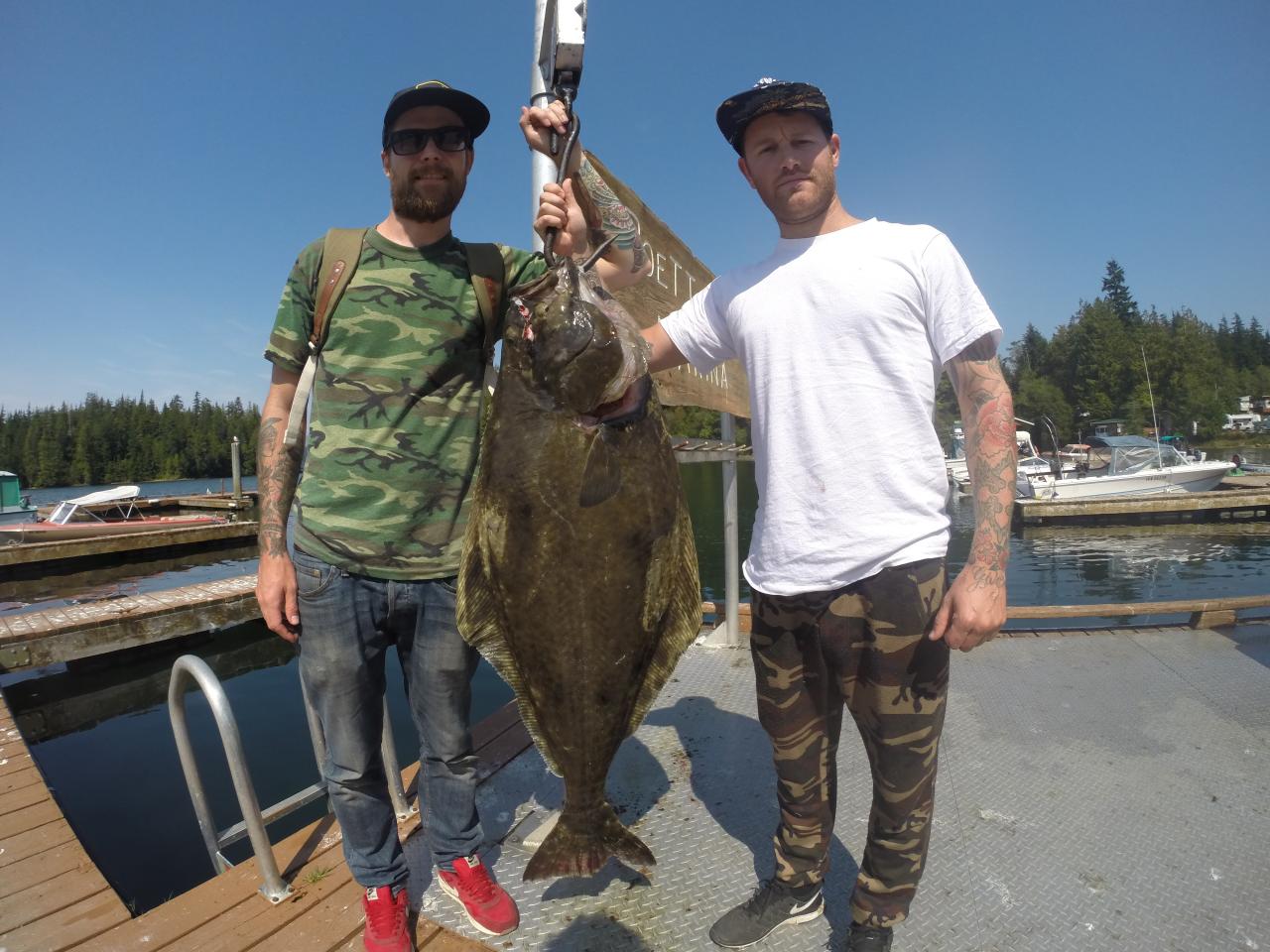 2 fishermen with 40 lb halibut hanging on a scale